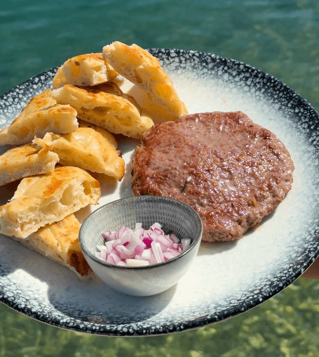 Grilled patty with homemade bread and onion over the Adriatic at Dandy, Zaton
